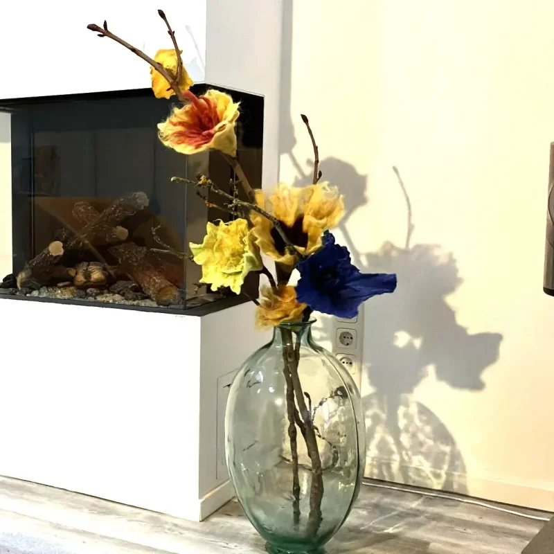 Gevilte bloemen op tak in glazen vaas Gevilte bloemen op tak in glazen vaas